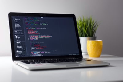 Laptop open on desk with code on screen